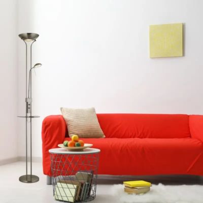 Lampadaire liseuse avec tablette à proximité d'un canapé rouge