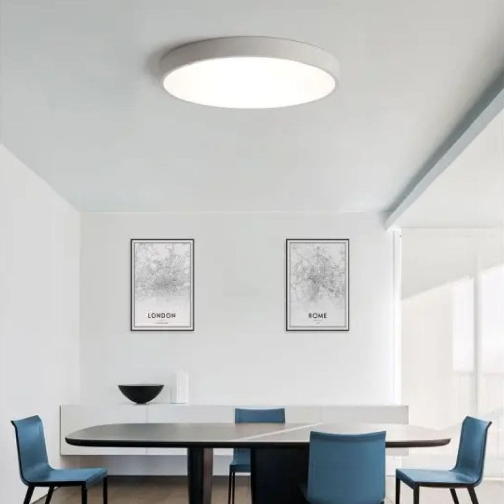 Plafonnier blanc Isia de la marque ACB dans une salle à manger avec des chaises bleu