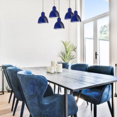 Luminaire à suspension araignée bleu foncé au-dessus d'une table à manger (modèle Venice de la marque Faro)