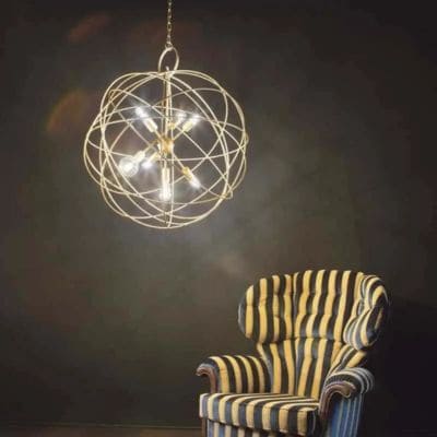 Lustre pissenlit or au-dessus d'un fauteuil noir et jaune (Modèle Konse, Ideal Lux)