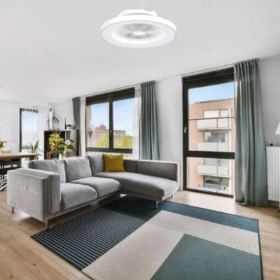 Ventilateur bébé nuit installé au plafond d’un salon moderne, ventilant l’air sans bruit près du canapé et des grandes fenêtres.
