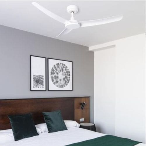 Ventilateur plafond silencieux installé au-dessus d’un lit dans une chambre, cadre minimal et ambiance paisible