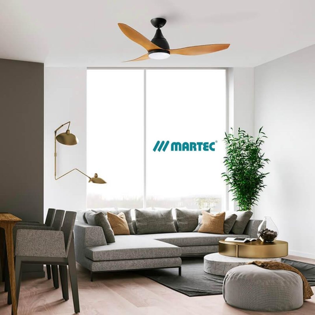 Salon lumineux avec canapé gris et table basse rondes, près d’une grande fenêtre et d’un vase planté vert, logo MARTEC