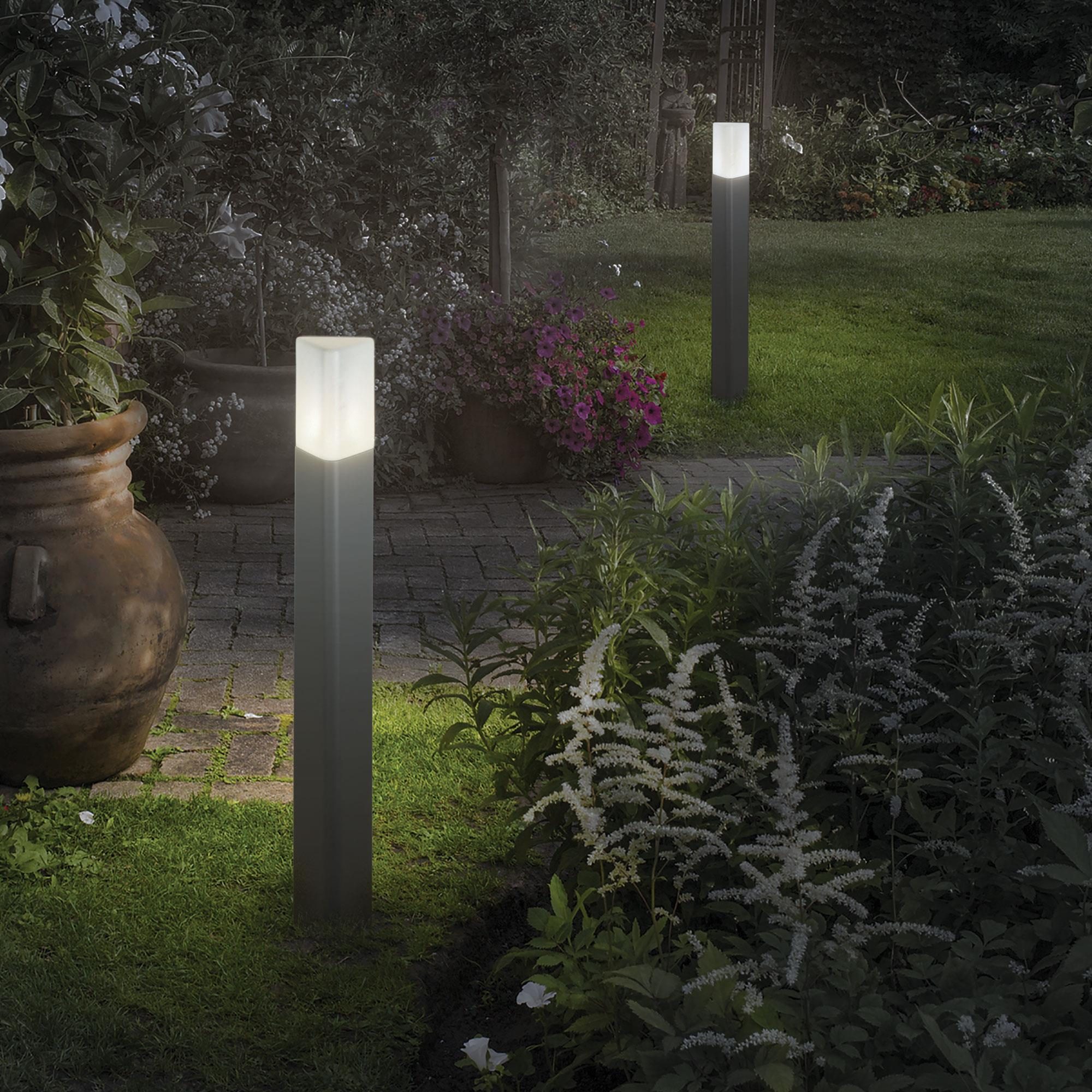Deux bornes lumineuses LED énonçant une lumière blanche douce dans un jardin nocturne.