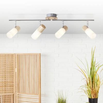 Éclairage suspendu avec quatre spots blancs montés sur une barre au plafond dans une cuisine lumineuse.