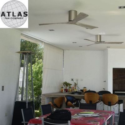 Un ventilateur de plafond avec trois pales dans une salle extérieure ou terrasse couverte.