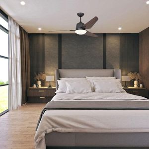 Vue d’ensemble d’une chambre moderne avec un lit double, deux tables de nuit et un plafond à ventilateur avec lumière.